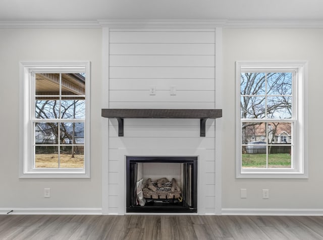 interior details with a large fireplace, crown molding, and hardwood / wood-style floors