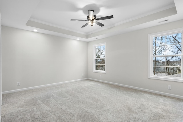 spare room featuring ceiling fan, a tray ceiling, and crown molding