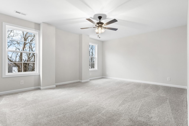 unfurnished room with ceiling fan, carpet, and a healthy amount of sunlight