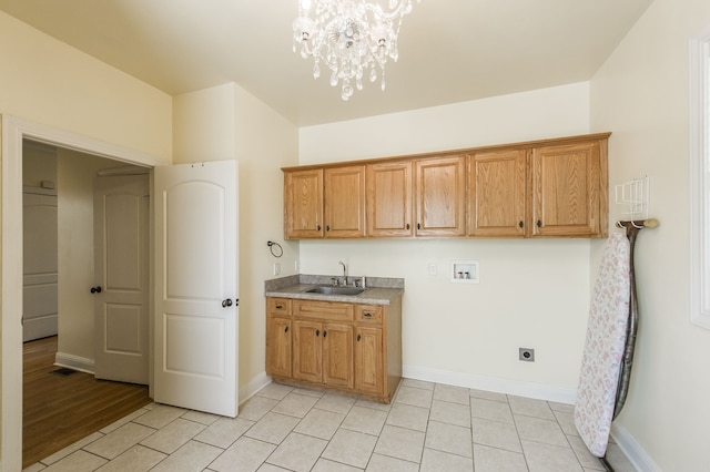 laundry room featuring sink, an inviting chandelier, electric dryer hookup, hookup for a washing machine, and light wood-type flooring