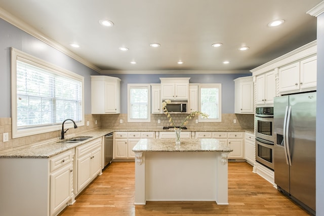 kitchen featuring a kitchen island, appliances with stainless steel finishes, sink, and plenty of natural light