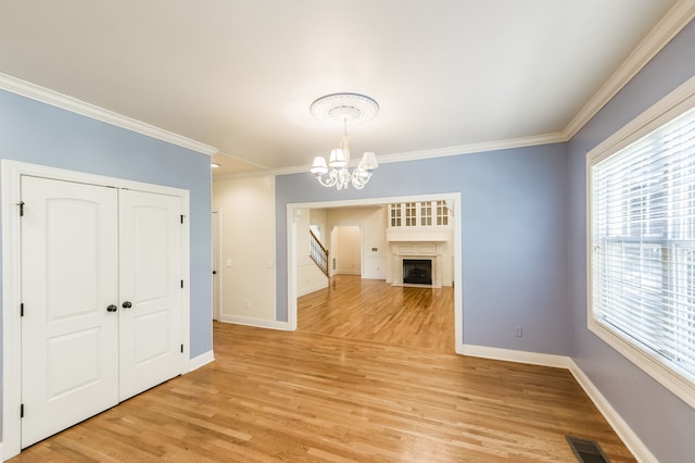 unfurnished dining area featuring light hardwood / wood-style floors, a notable chandelier, and ornamental molding