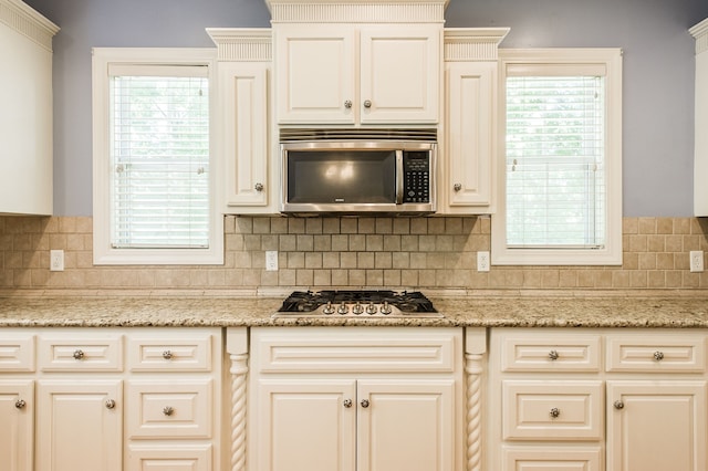 kitchen featuring a wealth of natural light, appliances with stainless steel finishes, and backsplash