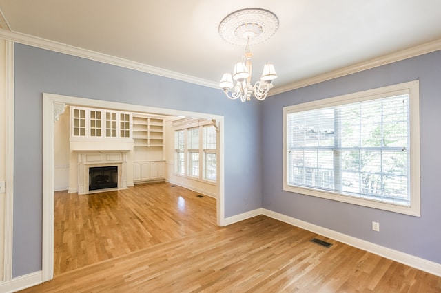 unfurnished living room with an inviting chandelier, wood-type flooring, and plenty of natural light