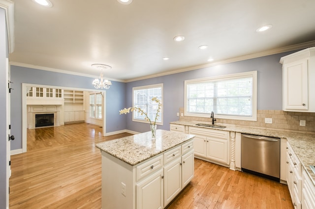 kitchen with sink, tasteful backsplash, stainless steel dishwasher, light hardwood / wood-style flooring, and white cabinets