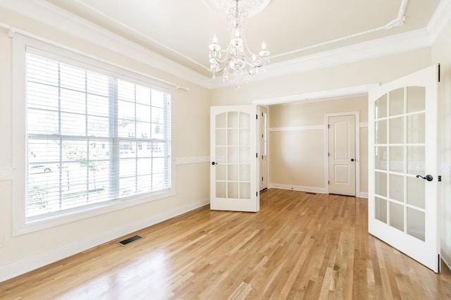 unfurnished room featuring a healthy amount of sunlight, light hardwood / wood-style flooring, and french doors