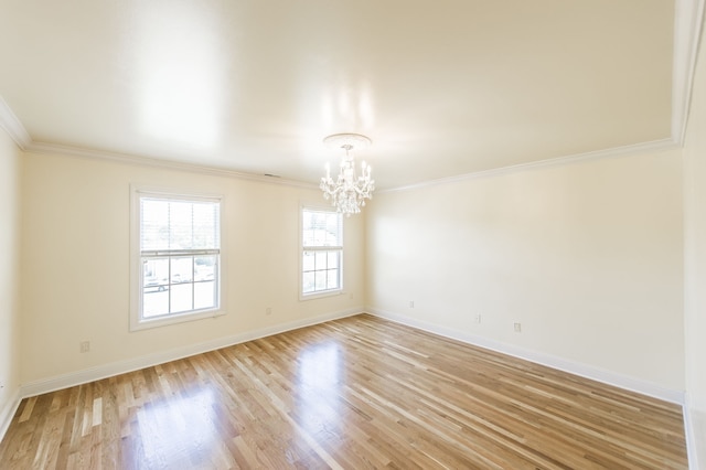 unfurnished room featuring ornamental molding, light hardwood / wood-style floors, and an inviting chandelier