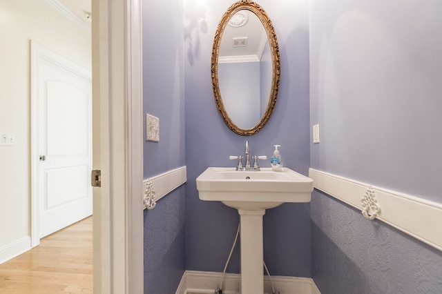 bathroom featuring wood-type flooring and crown molding