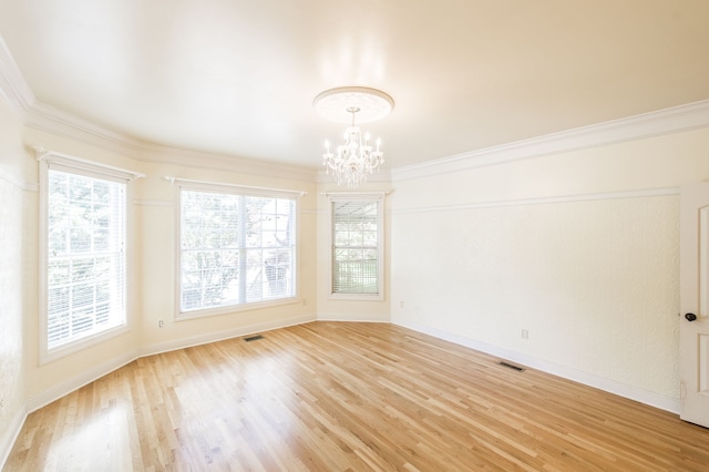 unfurnished room with hardwood / wood-style flooring, crown molding, and an inviting chandelier