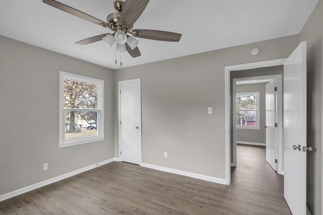 unfurnished room featuring a wealth of natural light, ceiling fan, and light hardwood / wood-style flooring