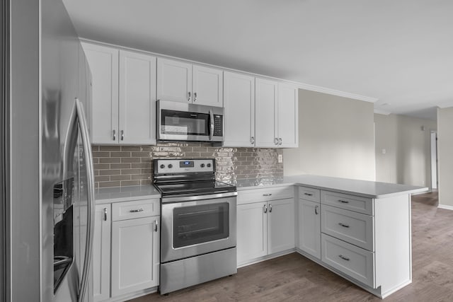 kitchen with white cabinets, kitchen peninsula, and stainless steel appliances