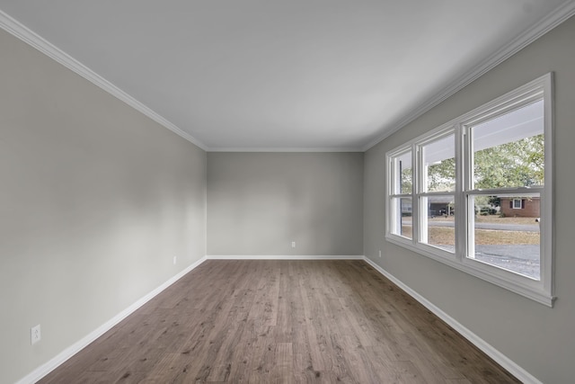 unfurnished room featuring hardwood / wood-style floors and crown molding