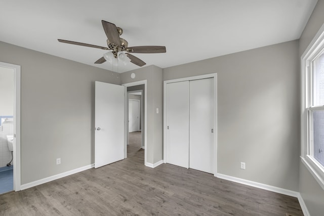 unfurnished bedroom with ceiling fan, a closet, and wood-type flooring