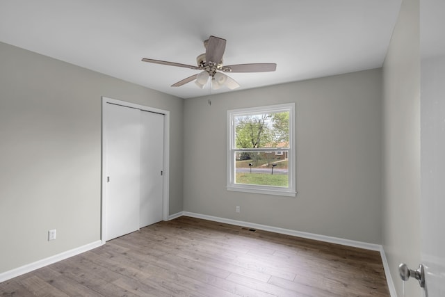 unfurnished bedroom with a closet, light wood-type flooring, and ceiling fan