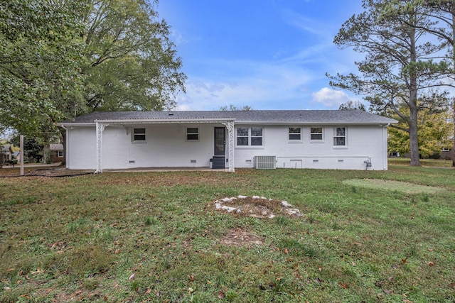 back of house featuring central AC unit and a yard