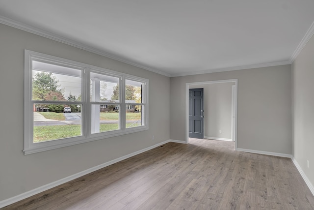 spare room featuring light hardwood / wood-style flooring and ornamental molding