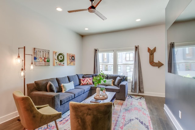 living room featuring dark wood-type flooring and ceiling fan