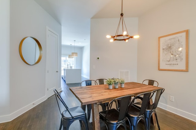 dining room with a notable chandelier and dark hardwood / wood-style floors