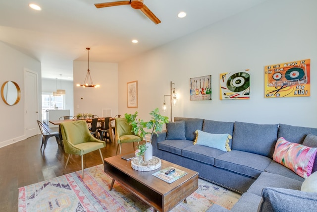 living room featuring ceiling fan with notable chandelier and wood-type flooring