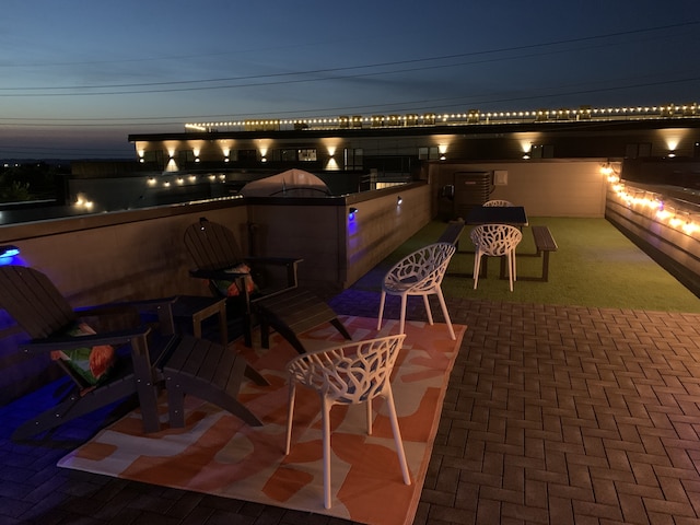 patio terrace at dusk featuring area for grilling