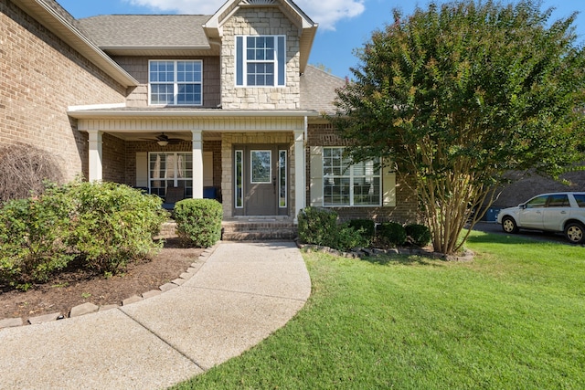 view of front of house with a porch, a front yard, and ceiling fan