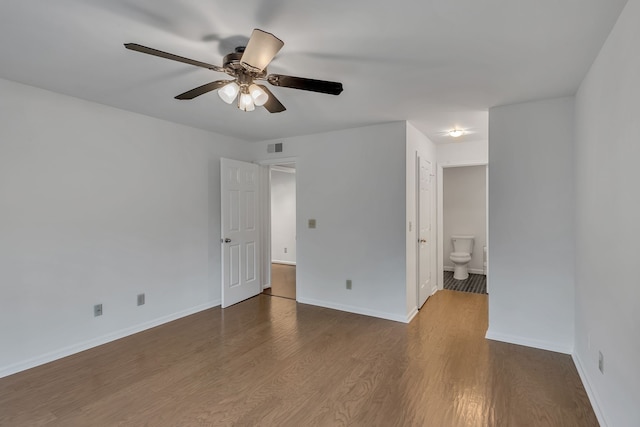 unfurnished bedroom featuring ensuite bath, ceiling fan, and dark hardwood / wood-style flooring