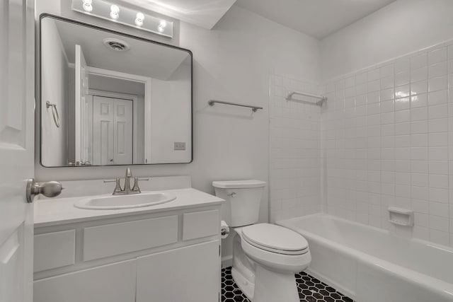 full bathroom featuring vanity, tiled shower / bath combo, and toilet