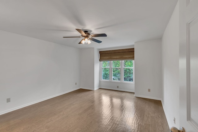 spare room with hardwood / wood-style floors and ceiling fan