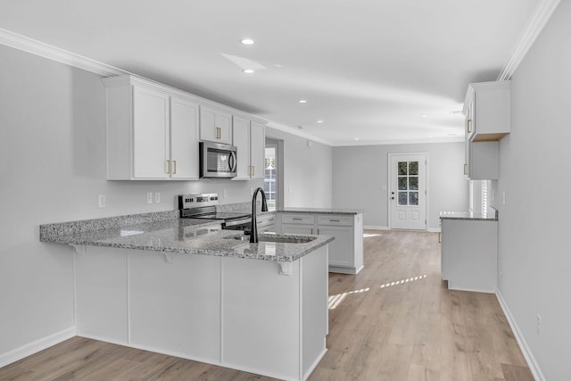 kitchen with crown molding, white cabinetry, stainless steel appliances, light stone counters, and kitchen peninsula