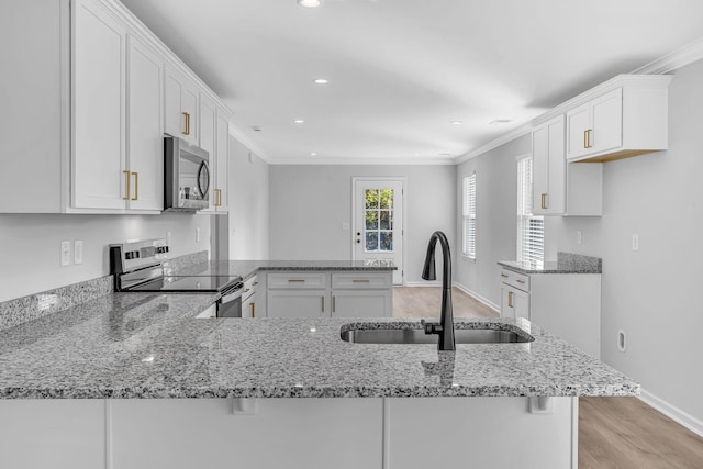 kitchen featuring sink, stainless steel appliances, light stone counters, white cabinets, and kitchen peninsula