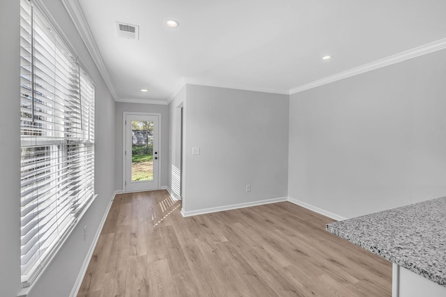 interior space with crown molding and light hardwood / wood-style flooring