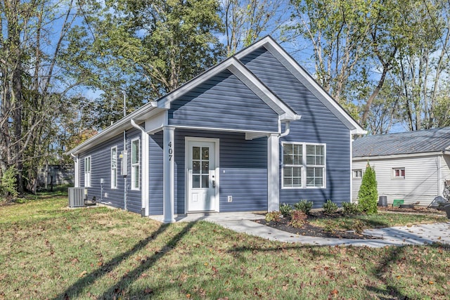 view of front of home with central AC unit and a front lawn