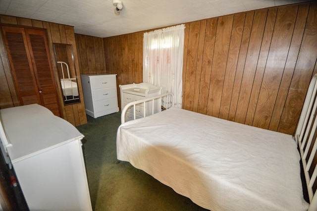 carpeted bedroom featuring wooden walls and a closet