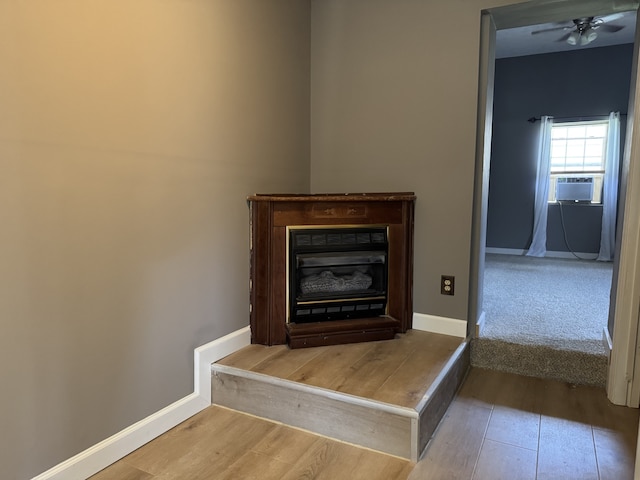 details featuring a fireplace, cooling unit, hardwood / wood-style flooring, and ceiling fan