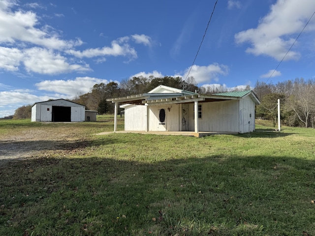 back of property featuring an outbuilding and a lawn