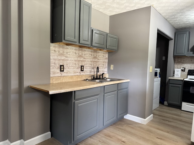 kitchen with white electric range, a textured ceiling, tasteful backsplash, and sink