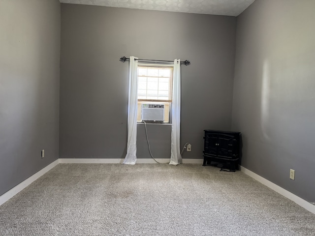 empty room with cooling unit, a textured ceiling, and carpet flooring