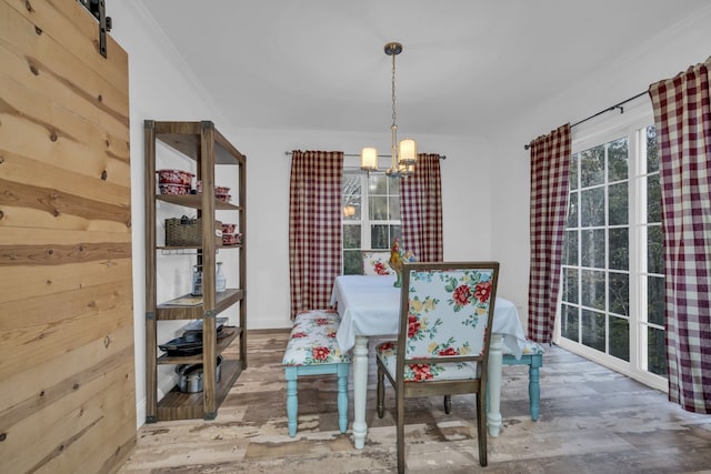 unfurnished dining area featuring a notable chandelier, a barn door, and crown molding