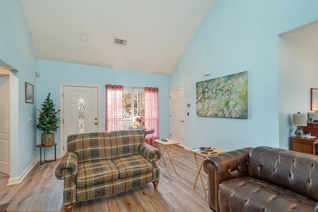 living room with high vaulted ceiling and light hardwood / wood-style floors