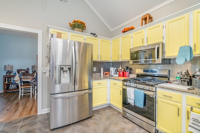 kitchen featuring decorative backsplash, appliances with stainless steel finishes, vaulted ceiling, and light hardwood / wood-style flooring