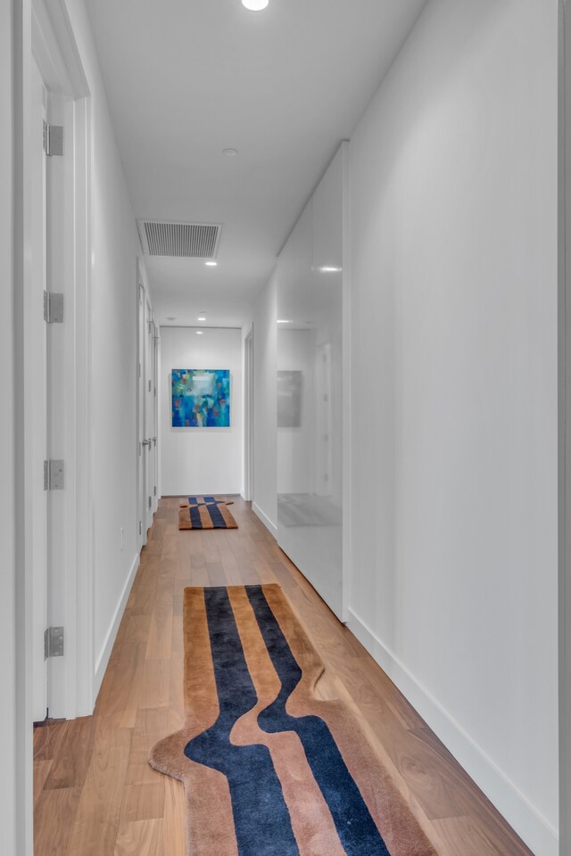 hallway with light hardwood / wood-style floors