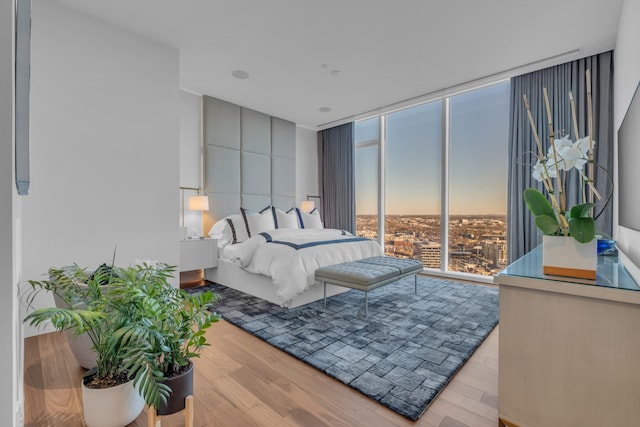 bedroom with light hardwood / wood-style flooring and a wall of windows