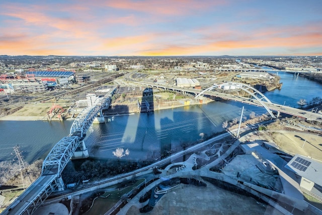 aerial view at dusk featuring a water view