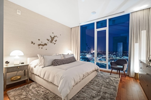 bedroom featuring hardwood / wood-style flooring, access to outside, and floor to ceiling windows