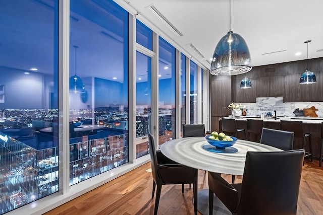 dining space featuring floor to ceiling windows, a chandelier, and light hardwood / wood-style floors