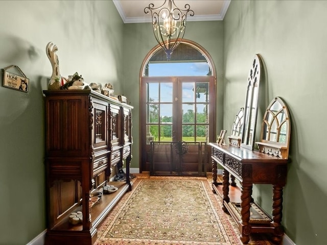 entryway featuring french doors, a chandelier, and crown molding