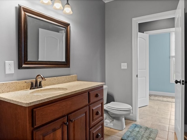 bathroom with toilet, vanity, and tile patterned flooring