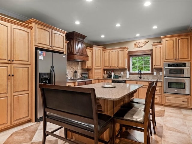 kitchen featuring tasteful backsplash, a kitchen island, appliances with stainless steel finishes, a kitchen bar, and sink