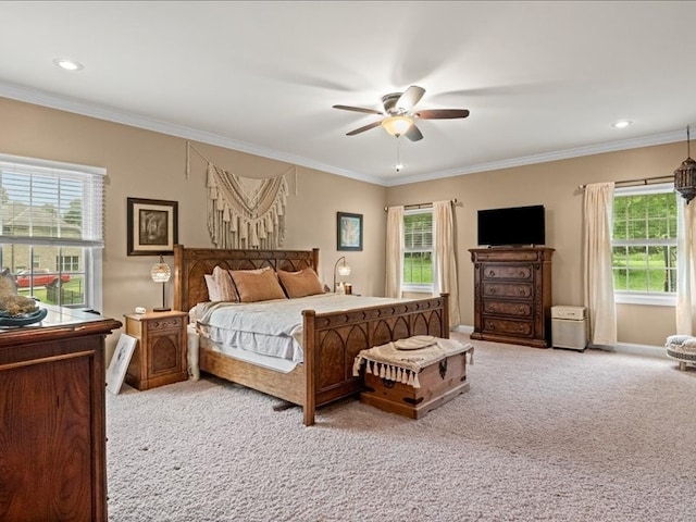 carpeted bedroom featuring ornamental molding, multiple windows, and ceiling fan