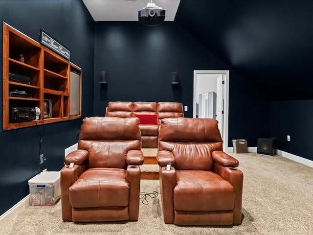 carpeted cinema room with vaulted ceiling